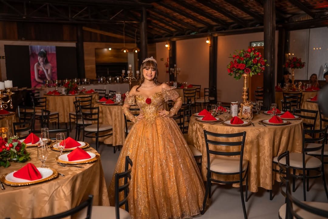 Debutante de vestido dourado no salão decorado para festa de 15 anos