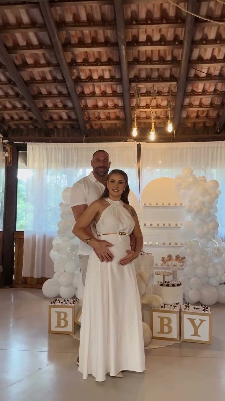 Casal no chá revelação com balões brancos e letras BABY